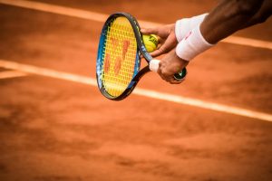 VĐV tennis giao bóng trên sân cứng trong một trận đấu căng thẳng